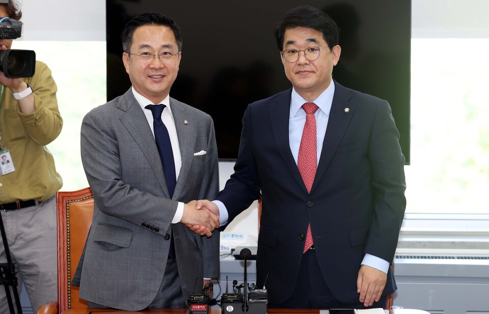박성준(왼쪽) 더불어민주당 원내수석부대표와 배준영 국민의힘 원내수석부대표가 26일 오전 서울 여의도 국회 운영위 소회의실에서 국회 의사일정 합의를 발표하기 전 악수를 하고 있다. [사진제공=뉴시스]