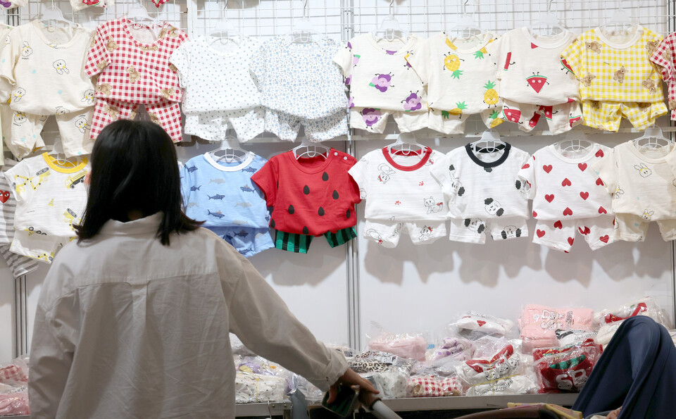 지난 5월 17일 인천 연수구 송도컨벤시아에서 개최된 ‘제28회 인천베이비&amp;키즈페어’를 방문한 한 관람객이 유아용 옷을 구경하고 있다. [사진제공=뉴시스]<br>