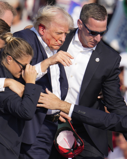 피격에도 목숨을 건진 미 공화당 도널드 트럼프 대선 후보가 경호원들과 함께 피신 중이다. [사진출처=AP/뉴시스]