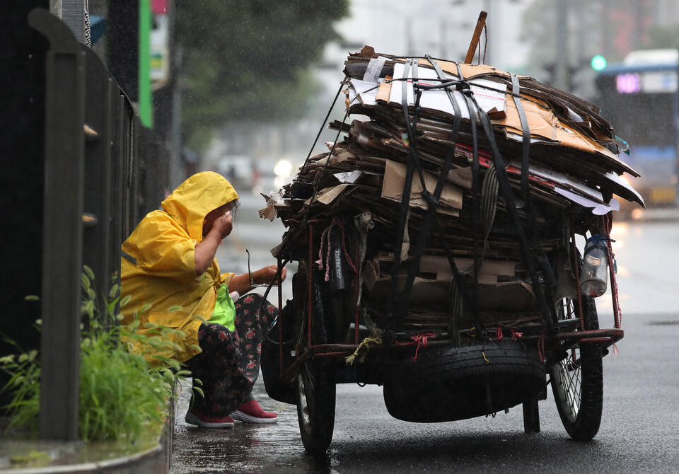 지난해 6월 26일 서울 성북구의 한 도로에서 폐지 줍는 노인이 폐지를 리어카에 싣고 가던 중 길가에 앉아 휴식을 취하고 있다. [사진제공=뉴시스]<br>