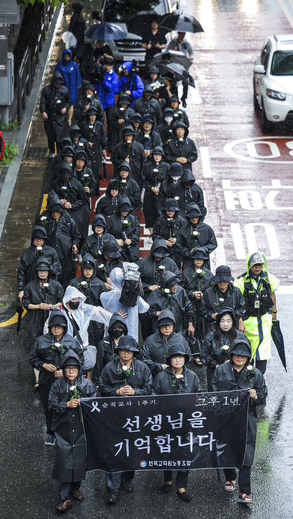 서이초 순직교사 1주기인 18일 서울 서초구 서울서이초등학교 앞에서 전국교직원노동조합 조합원 및 시민들이 국화꽃을 들고 국회 앞까지 추모행진을 하고 있다. [사진제공=뉴시스]
