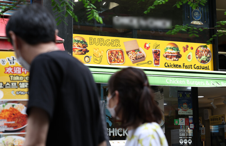 서울 시내에 위치한 한 버거 음식점 앞으로 시민들이 지나가고 있다. [사진제공=뉴시스]<br>