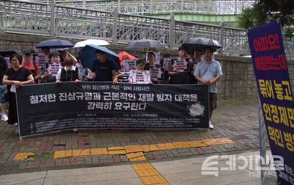 26일 부천 W진병원 앞에서 열린 결의대회에 정신장애인연합회가 현수막을 들고 있다. ⓒ투데이신문