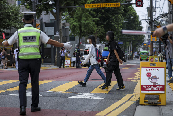 경찰 및 서울시청 직원이 서울의 한 초등학교 앞에서 어린이 보호구역 교통법규 위반을 단속하고 있다. [사진제공=뉴시스]
