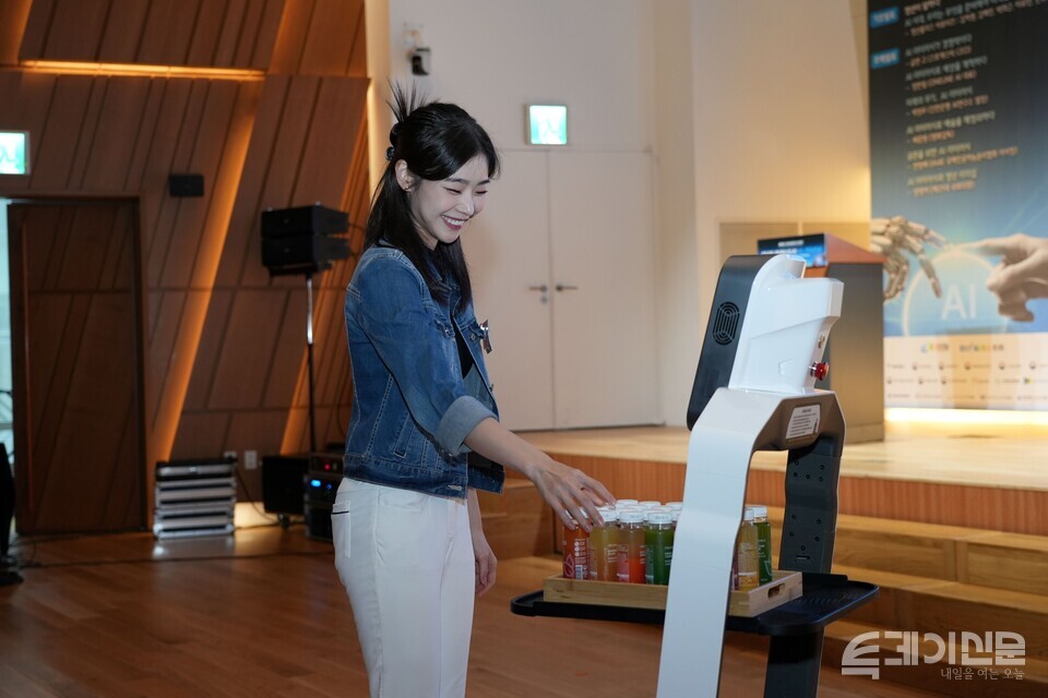 26일 ‘제6회 청년플러스포럼’에서 청년플러스포럼 홍보대사 배우 이혜원이 AI를 활용한 비로보틱스 배민 서빙로봇 ‘딜리플레이트S’에게 주스를 전달받고 있다.&nbsp;ⓒ투데이신문