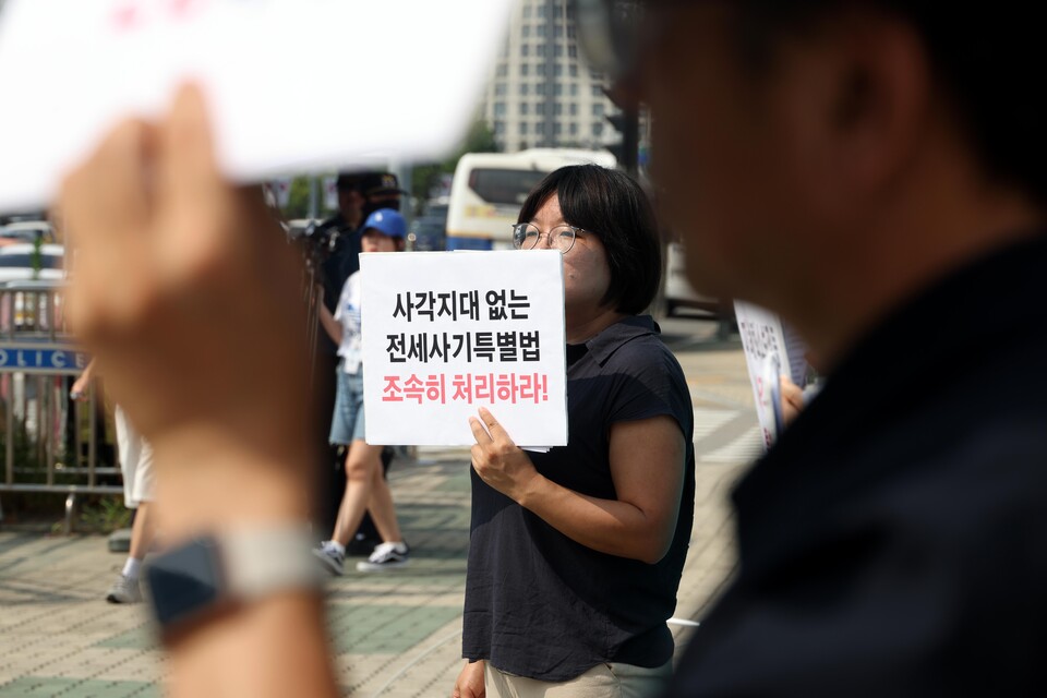 지난 8월 13일 서울 여의도 국회 앞에서 진행된 ‘전세사기특별법 개정 촉구 기자회견’에서 한 참석자가 손피켓을 들고 서 있다. [사진제공=뉴시스]