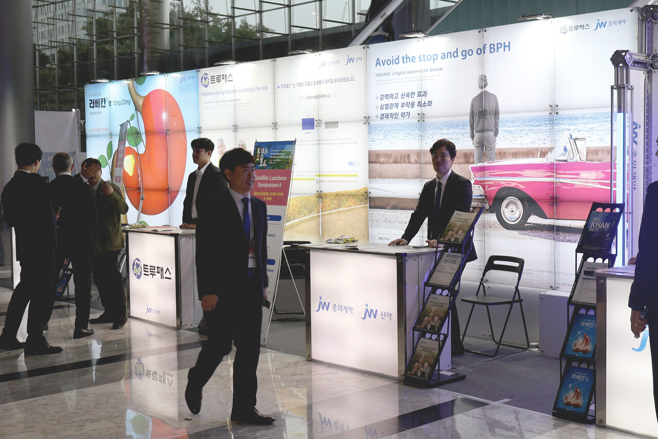 JW중외제약은 지난 16일부터 18일까지 서울 코엑스에서 열린 2024년 대한비뇨의학회 정기학술대회(KUA 2024)에 메인 부스를 마련했다. JW중외제약 관계자들이 메인 부스에서 전립선비대증 치료제인 ‘트루패스(성분명 실로도신)’를 소개하고 있다. [사진제공=JW중외제약]
