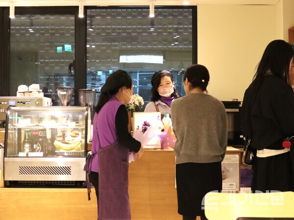 25일 일일카페 ‘보랏빛 하루’에서 청년과 대화하고 있는 이태원 참사 유족.&nbsp;ⓒ투데이신문