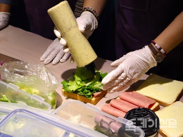 25일 일일카페 ‘보랏빛 하루’에서 이태원 참사 유족이 샌드위치를 만들고 있다. ⓒ투데이신문