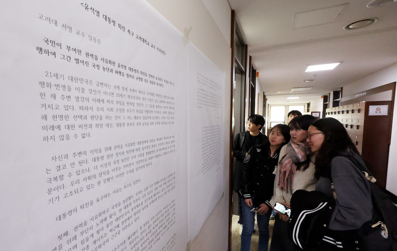 14일 서울 성북구 고려대학교에서 학생들이 윤석열 대통령 퇴진 촉구 고려대 교수 시국선언문 대자보를 살펴보고 있다. [사진 제공=뉴시스]