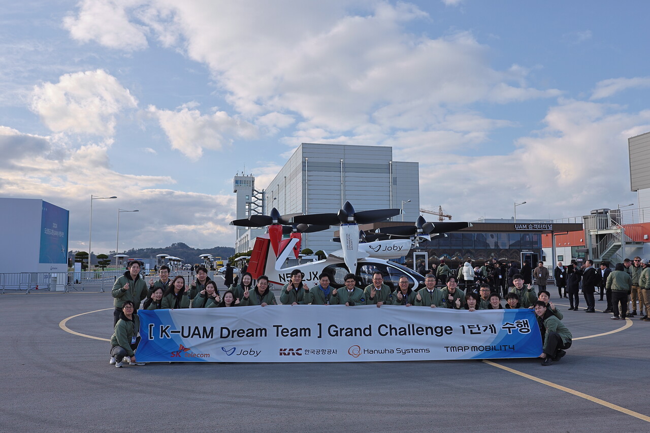 한국공항공사·SK텔레콤·한화시스템·Joby 사가 ‘K-UAM 그랜드챌린지’ 1단계 실증을 마치고 S-4 기체 앞에서 이정기(왼쪽에서 13번째) 공사 사장직무대행이 공사 직원들과 기념촬영을 하고 있다. [사진출처=한국공항공사/뉴시스]