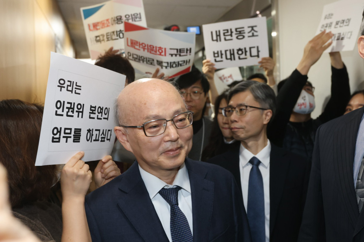 지난 13일 오후 서울 중구 인권위에서 국가인권위원회 전원위원회 회의장을 가로막은 규탄 시위에 안창호 위원장이 등을 돌리고 있다. [사진제공=뉴시스]