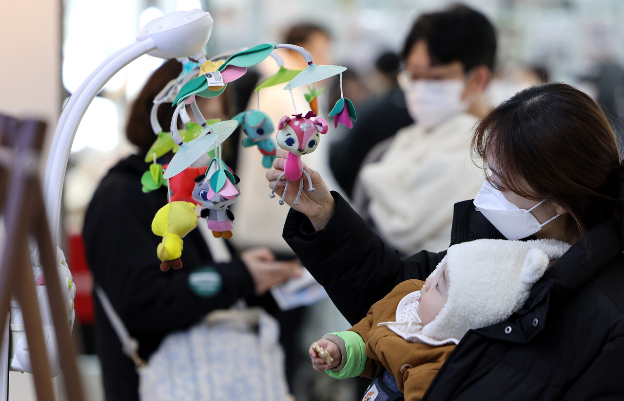 지난달 13일 대구 북구 엑스코에서 개최된 ‘제43회 대구 베이비&키즈페어’를 방문한 관람객이 유아용 모빌을 구경하고 있다. [사진제공=뉴시스]