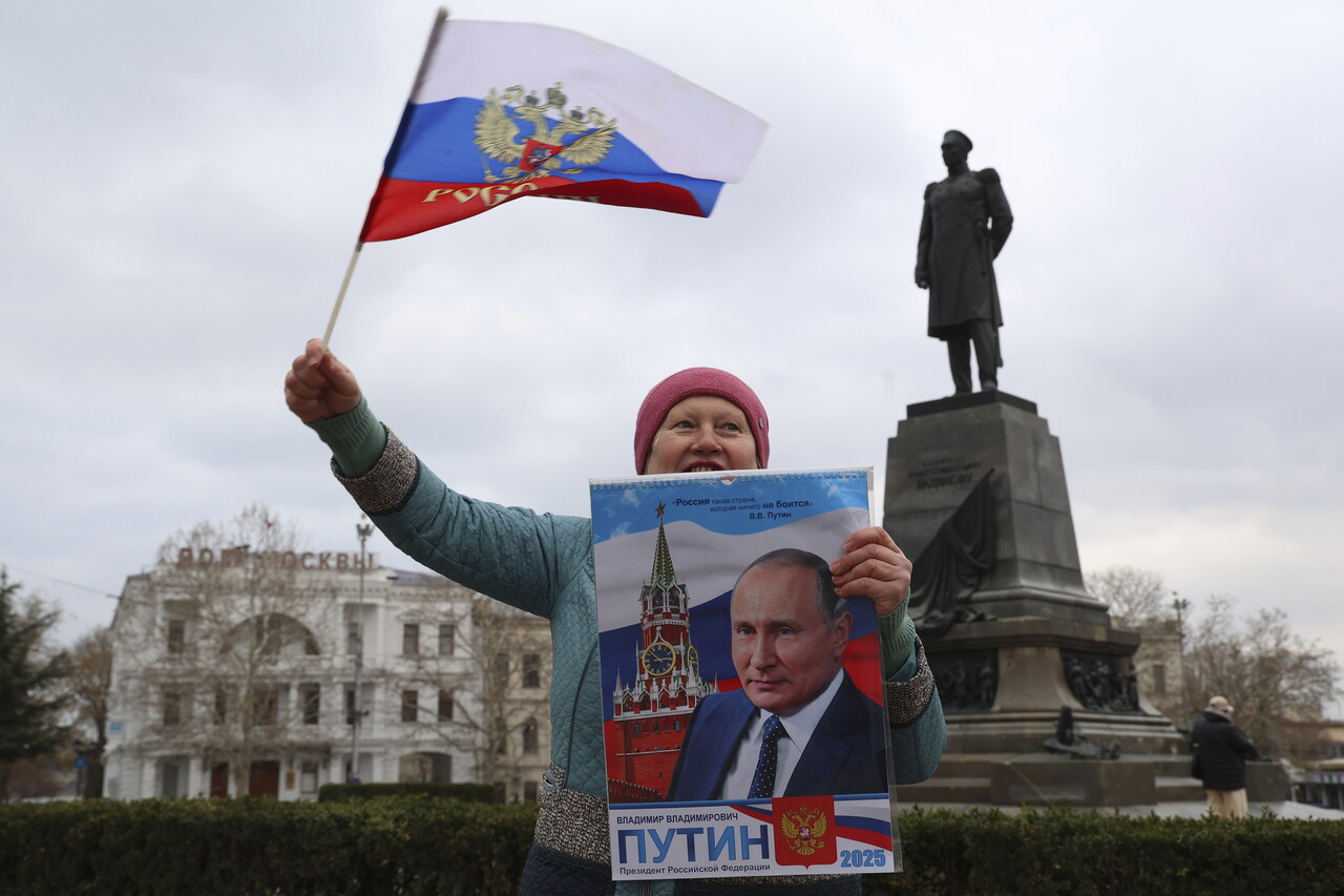 18일(현지시간) 한 여성이 크림반도 세바스토폴 광장에서 러시아 국기를 흔들며 크림반도의 러시아 합병 11주년을 기념하고 있다. [사진제공=AP/뉴시스]