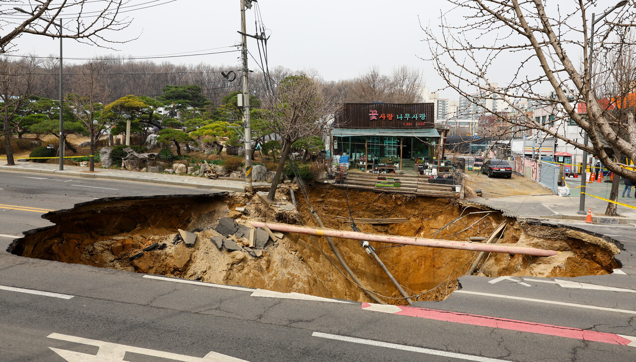 25일 서울 강동구 명일초등학교 인근 도로에서 전날 발생한 싱크홀 사고 현장 모습.&nbsp;[사진제공=뉴시스]