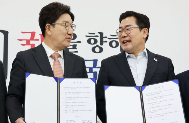 국민의힘 권성동 원내대표와 더불어민주당 박찬대 당 대표 직무대행 겸 원내대표가 1일 오전 서울 여의도 국회에서 추경안 합의문에 서명한 뒤 기념촬영을 하고 있다.&nbsp;[사진출처=뉴시스]<br>