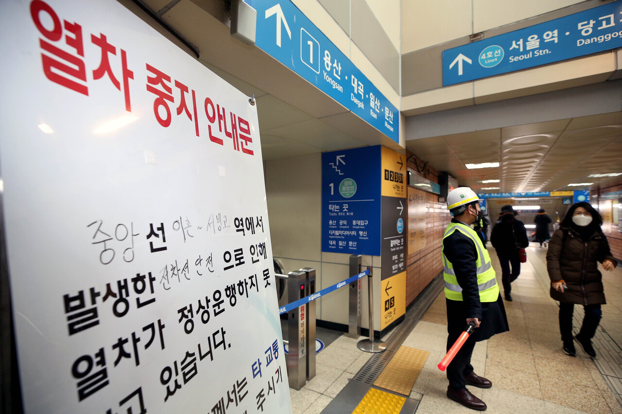 21일 오전 서울 용산구 경의·중앙선 이촌역에서 전기 공급 문제로 열차가 멈춰서 코레일 관계자들이 시민들을 통제하고 있다. [사진=뉴시스]