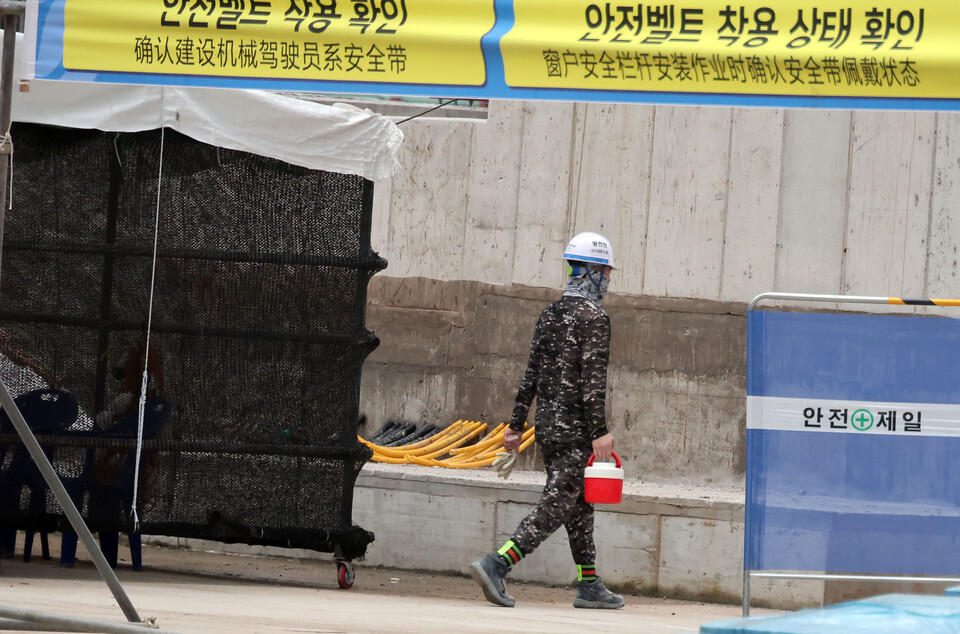 서울 성북구 소재 한 주택정비사업 건설현장에서 근로자가 음료를 든 채 걸음을 옮기고 있다. [사진=뉴시스]