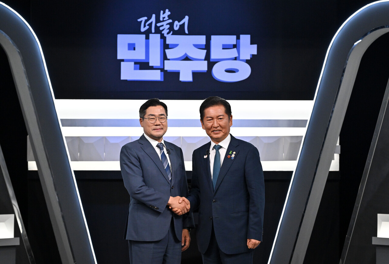 정청래(오른쪽), 박찬대 더불어민주당 당대표 후보가 지난 27일 오후 서울 여의도 KBS 신관 공개홀에서 TV토론회 시작 전 악수를 하며 포즈를 취하고 있는 모습. [사진제공=뉴시스]