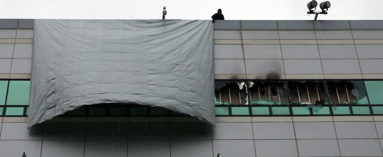 지난 28일 화재가 완진된 대전 유성구 국가정보자원관리원에서 관계자들이 깨진 창문 위로 방수포를 덮고 있다. [사진=뉴시스]