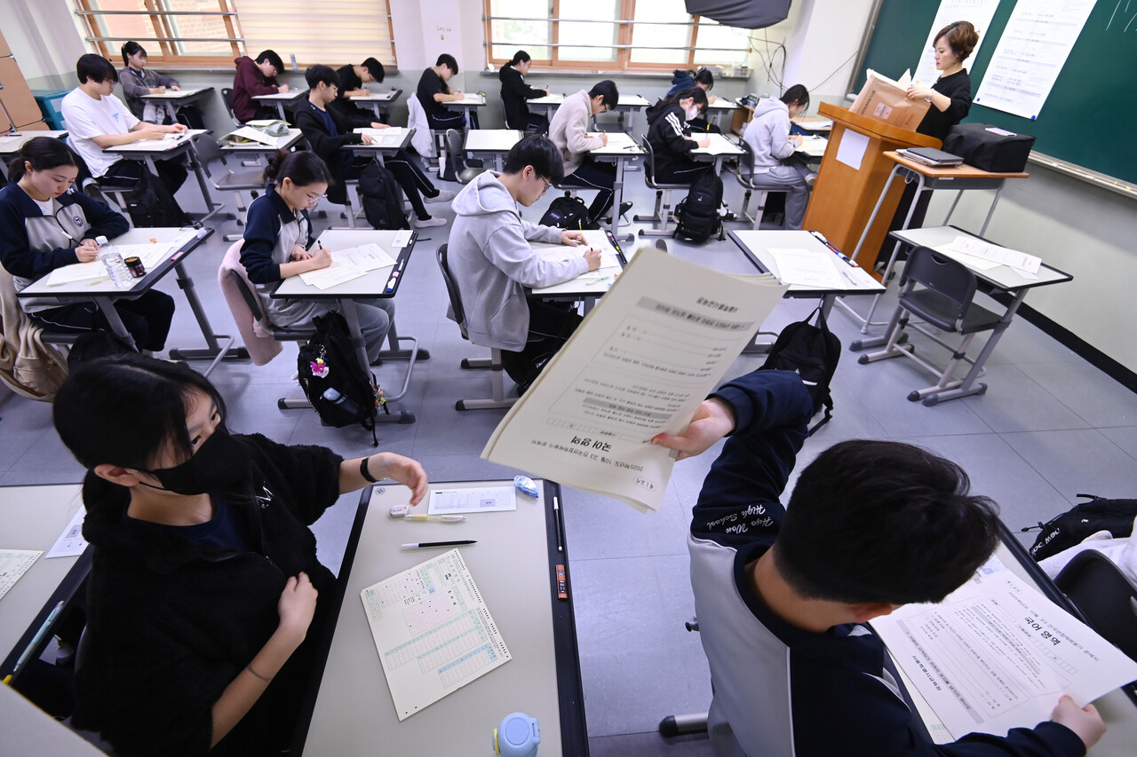 2026학년도 대학수학능력시험을 앞두고 마지막 모의고사인 전국연합학력평가가 실시된 14일 경기 수원시 효원고등학교에서 고3 수험생들이 문제지를 전달하고 있다. [사진제공=뉴시스]