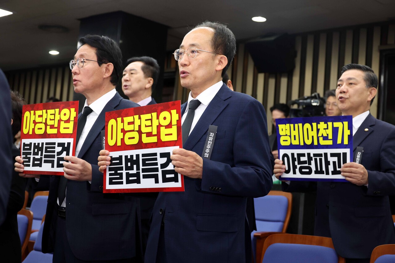 국민의힘 추경호 의원이 지난 4일 오전 서울 여의도 국회에서 진행된 의원총회에서 ‘야당 탄압’, ‘불법 특검’이 적힌 손피켓을 들고 있다. [사진제공=뉴시스]