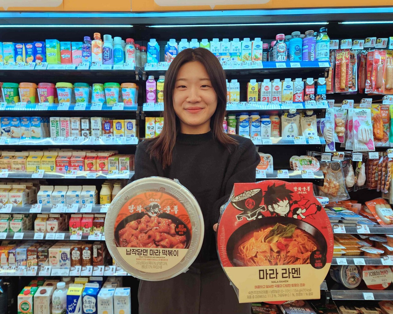 이마트24 관계자가 ‘탕화쿵푸마라탕’ 협업 간편식을 들어 보이고 있다. [사진=이마트24]